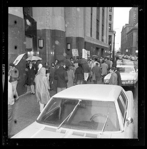 Pickets sympathetic with Dr. Spock and other defendants march outside Boston's Federal Building