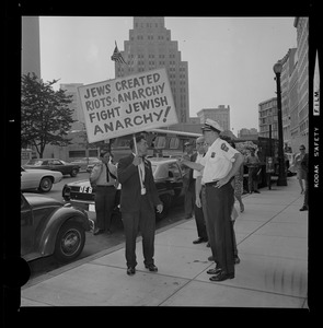Josef Mlot-Mroz holding sign outside the Federal Building in Boston during protests after the sentencing of Dr. Spock and the other "Boston Five" on draft conspiracy charges