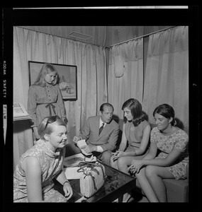 Unidentified man taking notes while talking to four unidentified young women
