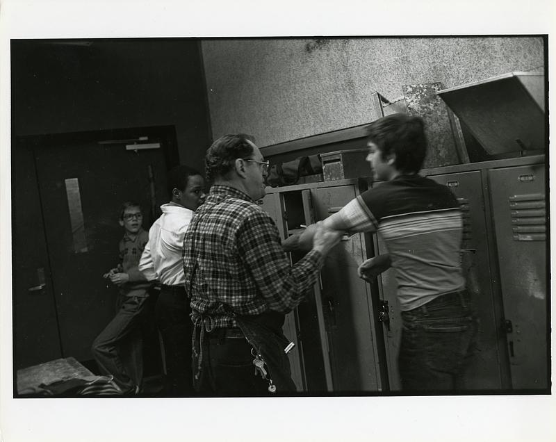 Teacher grabbing a student in carpenter class