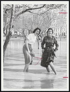 Two Girls go wading on their way to Katharine Gibbs school as water floods from Boston Common. They are Gail Gallagher, left, and Gail O’Hearn.