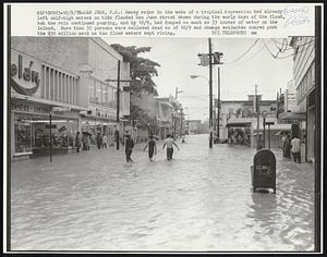 San Juan, P.R.: Heavy rains in the wake of a tropical depression had already ;eft calf-high waters on this flooded San Juan street shown during the early days of the flood, but the rain continued pouring, and by 10/9, had dumped as much as 33inches of water on the island. More than 35 persons were believed dead as of 10/9 and damage estimates soared past the $50 million mark as the flood waters kept rising.