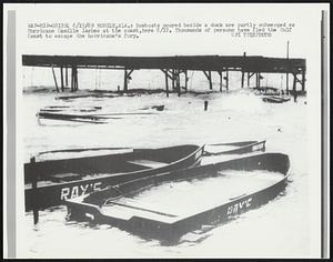 Rowboats moored beside a dock are partly submerged as Hurricane Camille lashes at the coast, here 8/17. Thousands of persons have fled the Gulf Coast to escape the hurricane's fury.