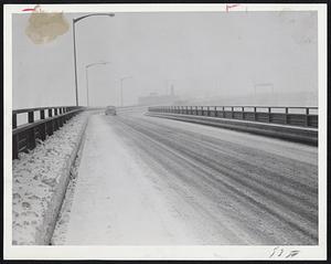 Single Car makes its way through today's big storm on down approach of Mystic River Bridge, Charlestown, to Boston. This photo was taken during morning rush hours when area is usually thronged with cars.