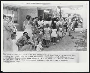 Waiting for Inoculation--A long line of mothers and their children wait their turn in a mass experiment of inoculation of children in polio-plagued Houston with gamma globulin, a blood fraction. Medical scientists believe the blood faction can prevent paralysis from polio.