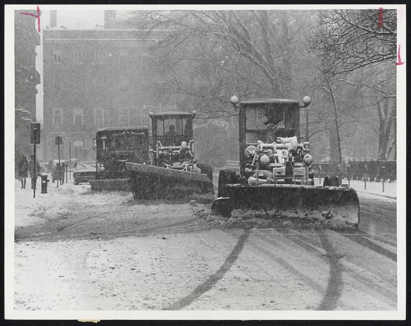 In Echelon, three plows scrape the snow off Arlington street, near Commonwealth avenue. Gale force winds kept driving snow back on roadways within minutes after plows passed.