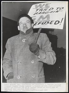 Detroit – Typical UAW Picket – G.W. Husband (above), striking General Motors Employe, bundles up with heavy overcoat, gloves and stocking cap as he carries banner in picket line at Chevrolet gear and axle plant today.