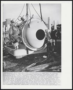 New Diving Bell-- A new type of diving bell developed by the International Underwater Research Corp. of Providence, R.I., waits aboard a lighter at Newport Shipyard, for the start of an eight-hour dive in about 130 feet of water scheduled to be made this afternoon to demonstrate its capabilities. The six-foot tall cylinder will carry two-man crew and has been designed to reach a depth of 1000 feet, primarily for salvage operations. The bell was tested yesterday in 15 feet of water and will make its deeper demonstration dive this afternoon in the East Passage of Narragansett Bay off Jamestown Island.