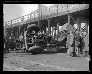People gather by an overturned truck