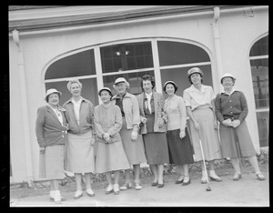 Women golfers pose in front of club house