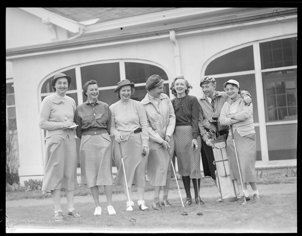 Women golfers pose in front of club house