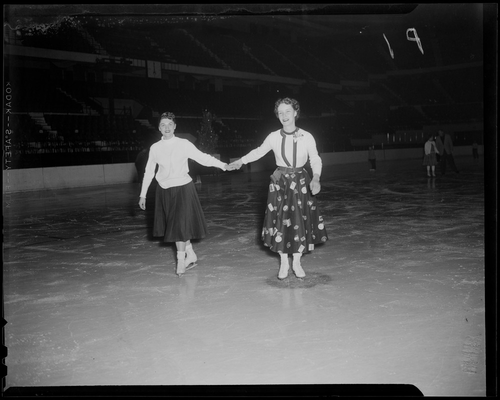 Two ladies skate on Garden ice during the Bruins, Christmas party