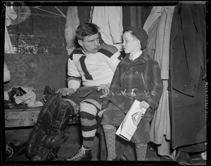 Frank Brimsek of the Bruins in locker room of Boston Garden with youngster