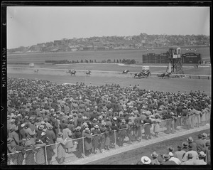 Crowd watches as the winner crosses the finish line at Suffolk Downs