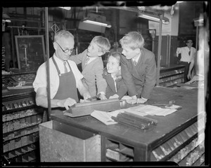 Clarence DeMar in print shop with kids