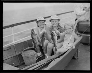 Three little girls in dory show their catch