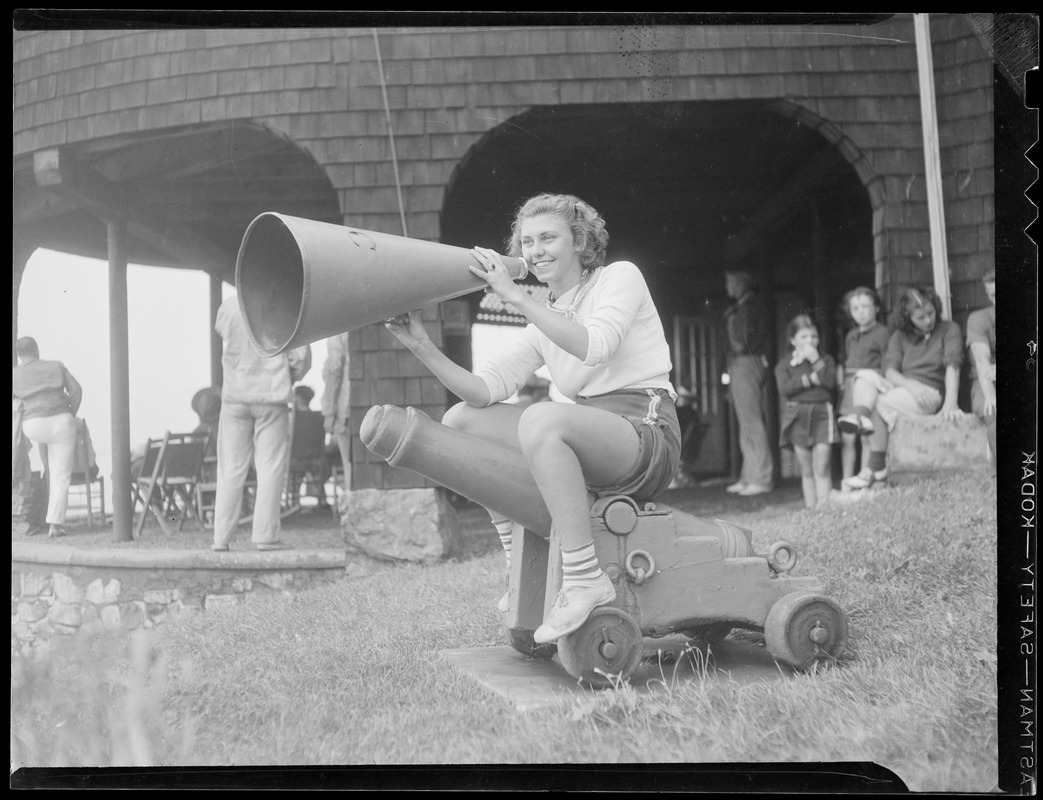 Girl seated on starting cannon with bullhorn