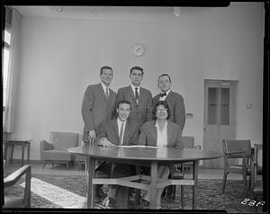 Five students behind a table