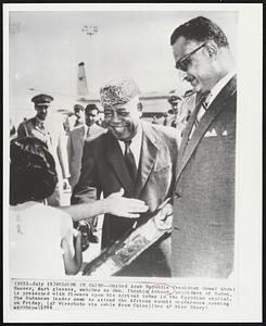 Welcome in Cairo--United Arab Republic President Gamal Abdel Nasser, dark glasses, watches as Gen. Ibrahim Abboud, president of Sudan, is presented with flowers upon his arrival today in the Egyptian capital. The Sudanese leader came to attend the African summit conference opening on Friday.