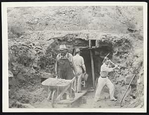 Gold Fever is Raging Again in West. Old, deserted gold mines are being opened up again in Colorado since the announcement of President Roosevelt's gold-buying plan and the discovery in Mancos, Colo., of rich veins of gold-bearing ore. These men are shown opening up an old shaft almost on the site of the first gold discovery in Colorado.... Sending thousands of men swarming into the mountain canyons in search of the Yellow Metal. A monument marking the spot where gold was first discovered may be seen in the right background. Mine near Idaho Springs, Colo