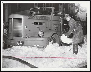 Shovel Duty for Fireman Fred Cuqua after ladder truck became lodged in snowbank in front of 138 Marcella St., Roxbury. Two-alarm blaze there caused $5,000 damage to three-family house.