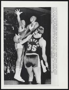 Elgin Baylor of the Los Angeles Lakers blocks Johnny Green of the New York Knickerbockers as he tries for a layup shot 11/12 at Madison Square Garden. Rudy LaRusso (35) of the Lakers watches the play. Los Angeles won, 132-123, in overtime.