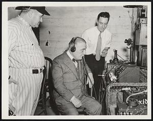 Transmitting From the Scene of Action--Jacob Ruppert, owner of the New York Yankees, listening in on the transmission of a World Series Baseball action picture sent by the telephone by a Wide World Wired Photo portable transmitter beneath the stands of The Yankee Stadium. Joseph McCarthy. manager of the Yankees, shown at the left, and John Schildmecht, technician, look on. By transmitting this picture direct from the scene of action, much time was saved and enabled subscribers receiving it to score beats in their respective cities. This picture is sent you for possible promotional purposes in connection with your use of the Wide World Wired Photo system.