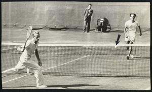 The South American Way - Alejo Russel, Argentine net ace (far court), drops a teaser just over the net to add to the woes of 31-year-old Sidney Wood, Jr., who was belted out of the national singles championships yesterday at Forest Hills by things like the above.