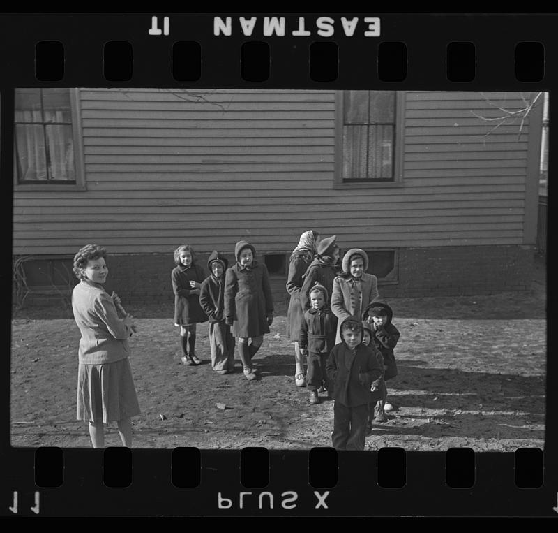 Children in yard, possibly with a teacher