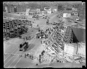 A crane tilting to its side near construction or demolition