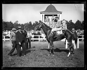 A jockey sitting on horse number 4