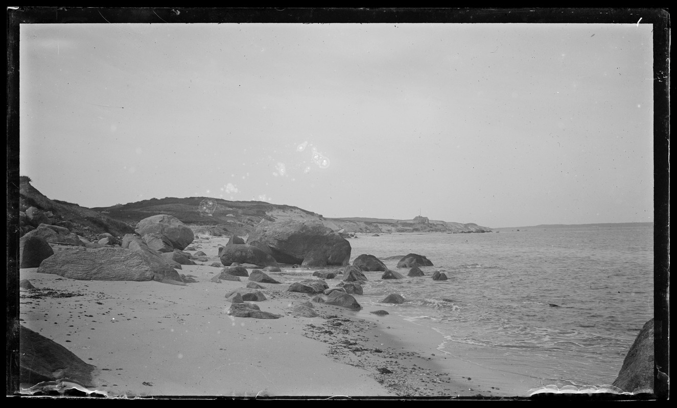 Rocks at shore & house in background