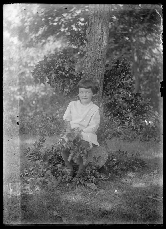 Girl sitting by tree