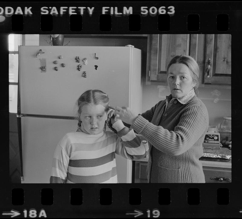 Mrs. John O'Donnell braiding daughter's hair