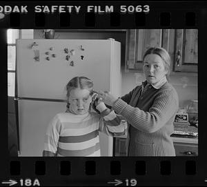 Mrs. John O'Donnell braiding daughter's hair