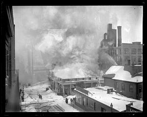 Firefighters using water hoses on a burning building