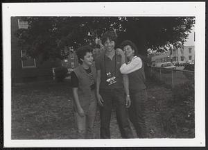 Teenage boy with camera and with two women on either side of him