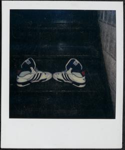 Pair of white and black Adidas shoes on stairs