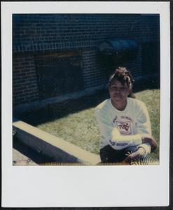 Girl in white sweatshirt sitting outside, possibly at Newtowne Court