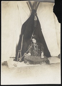 Seated woman dressed as an Indian smoking a pipe