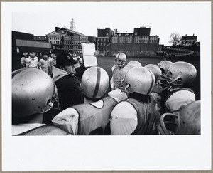 Coach and football team during practice
