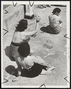 With the dart craze becoming increasingly popular among the fair sex at Margate, England, these pretty girls devised this novel means of enjoying a game at the seaside with the aid of suction darts and some lipstick.