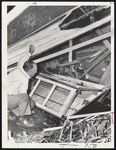 Unwelcomed intruder in Milton was this huge tree, felled by Donna. Ray A. Hinds of 52 Hollis St. surveys his car and garage, both wrecked in the topple.