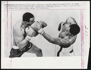 Champion Cassius Clay (R) smashes left to Sonny Liston's face during their title match here 5/25. Clay scored a first round knockout to retain his heavyweight crown.