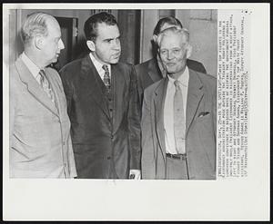 In the Spotlight--Three top figures in the Eisenhower administration pose outside of the Treasury today following a luncheon conference to discuss ways of keeping the government running smoothly while President Eisenhower is recuperating from a heart attack. Left to right are Attorney General Herbert Brownell, Vice President Richard Nixon and Sherman Adams, Eisenhower's top White House assistant. Behind Adams is William P. Rogers, Deputy Attorney General.