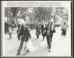 Antiwar demonstrators file past riot-trained police as they leave their encampment along the Potomac River 5/2 after their permit for the camp was revoked by officials. All but a handful of the protesters moved out of the camp after being informed they could no longer camp at the West Potomac River.