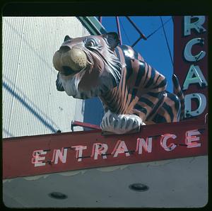 A statue of a tiger over a neon sign