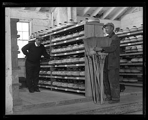 Two men with curling stones and brooms