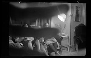 Five women sit on a couch by a lamp