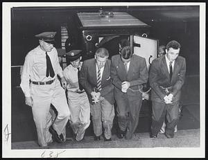 Manacled Walpole State Prison con victs are escorted into Dedham courthouse where they face 90 charges stemming from March 7 riot at the prison. Left to right, Kenneth E. Abramson of Worcester, George T. Harrison of Somerville and Martin P. Feeney of Dorchester.